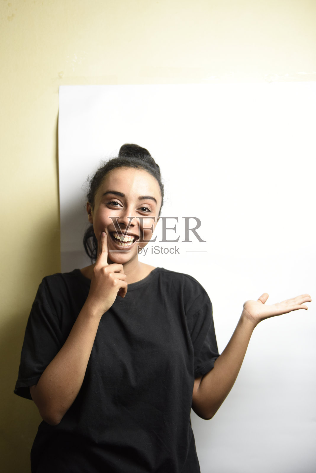 站立的中东女孩展示手中的物品并微笑照片摄影图片