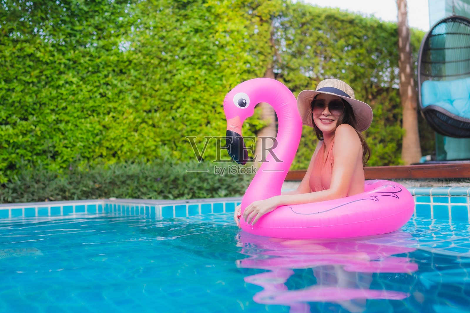 在酒店游泳池旁放松微笑的年轻亚洲女子肖像照片摄影图片