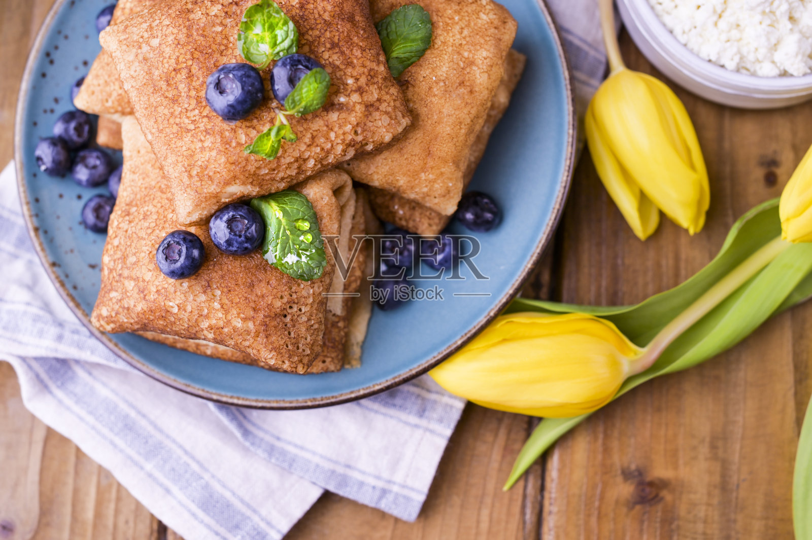 薄煎饼配白软干酪和草莓。健康传统早餐理念。为俄罗斯传统的春季狂欢节烘焙，马斯伦尼察。副本的空间。照片摄影图片