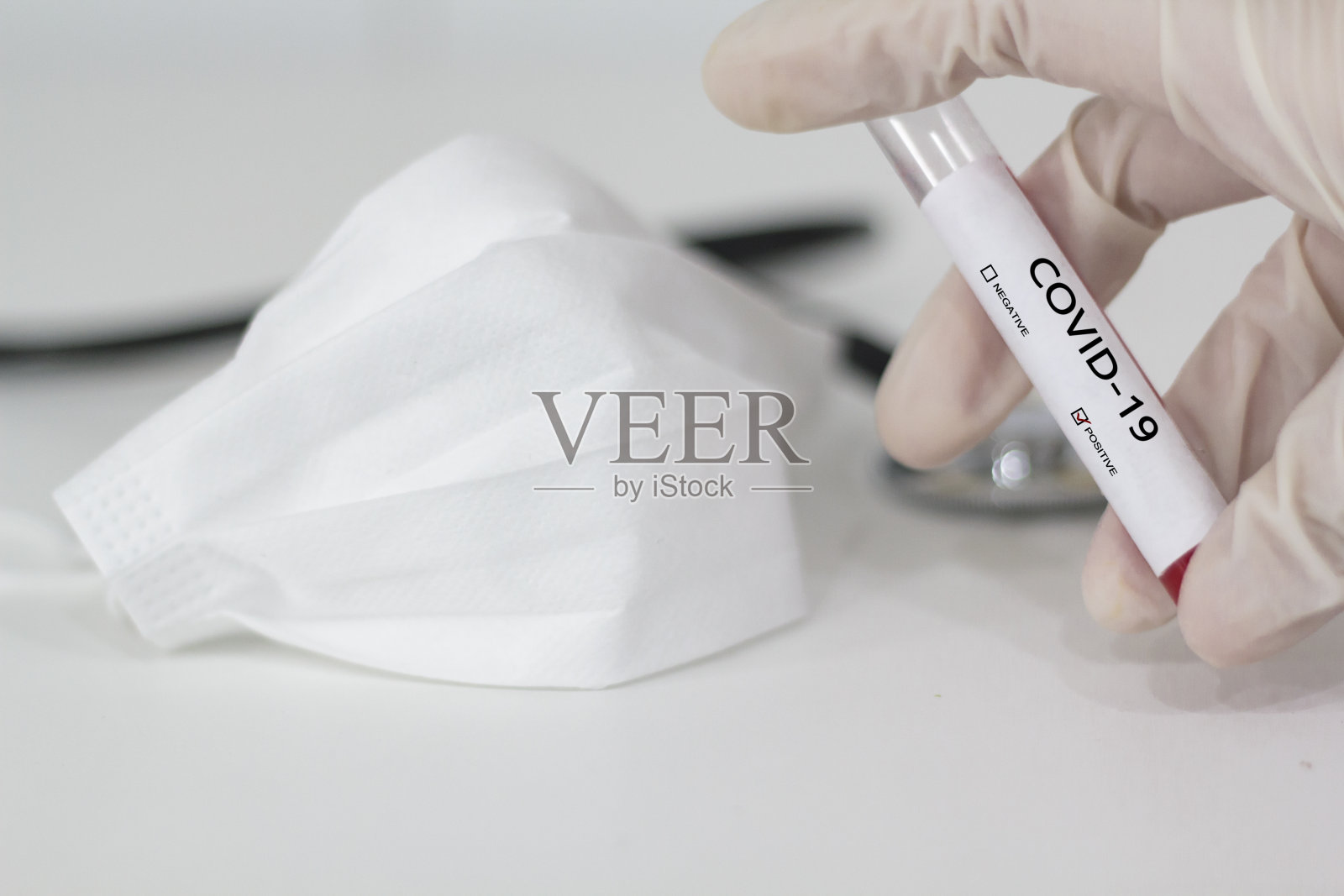 戴着手套的手拿着COVID-19阳性血液样本照片摄影图片