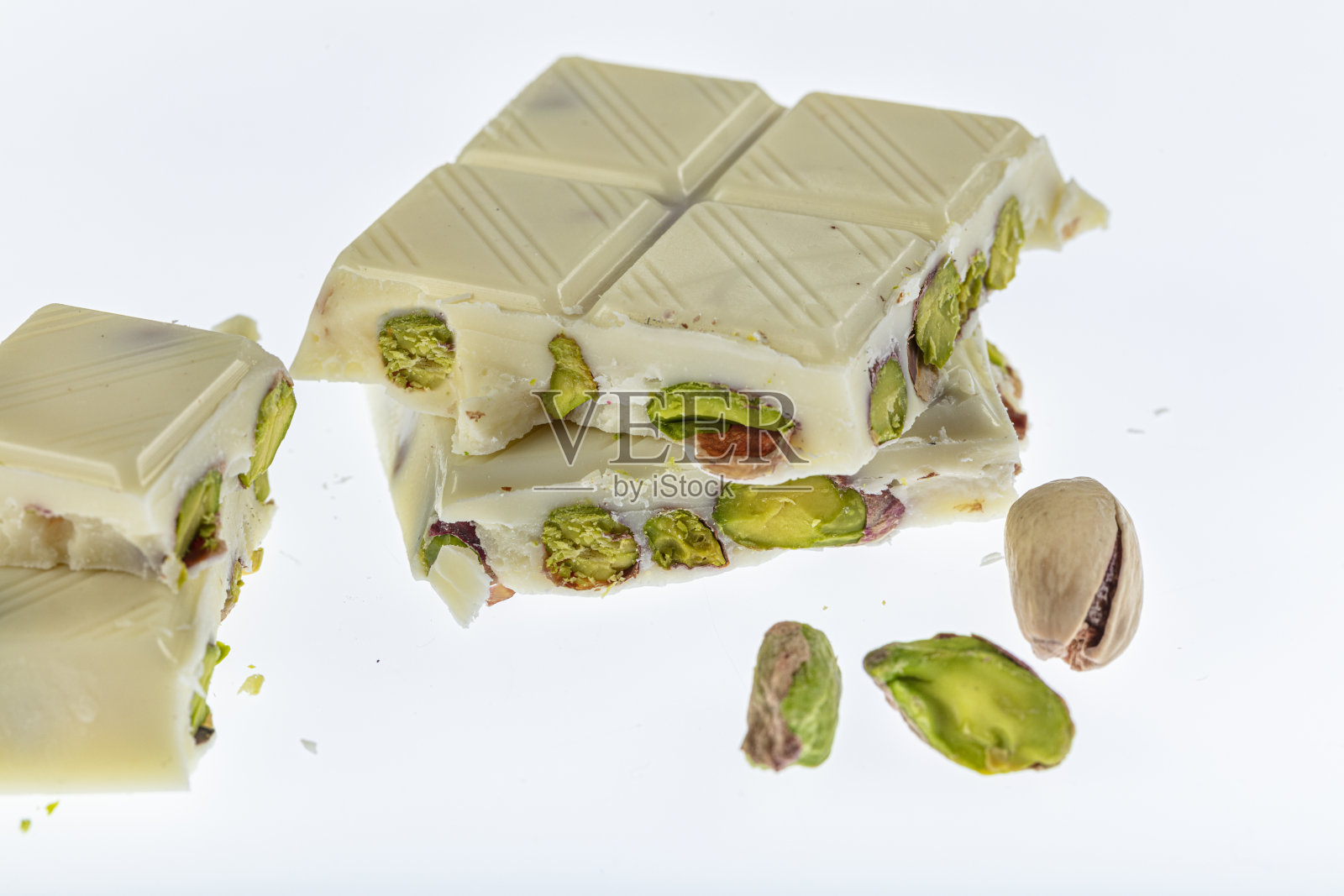 白巧克力与开心果孤立在白色背景。照片摄影图片