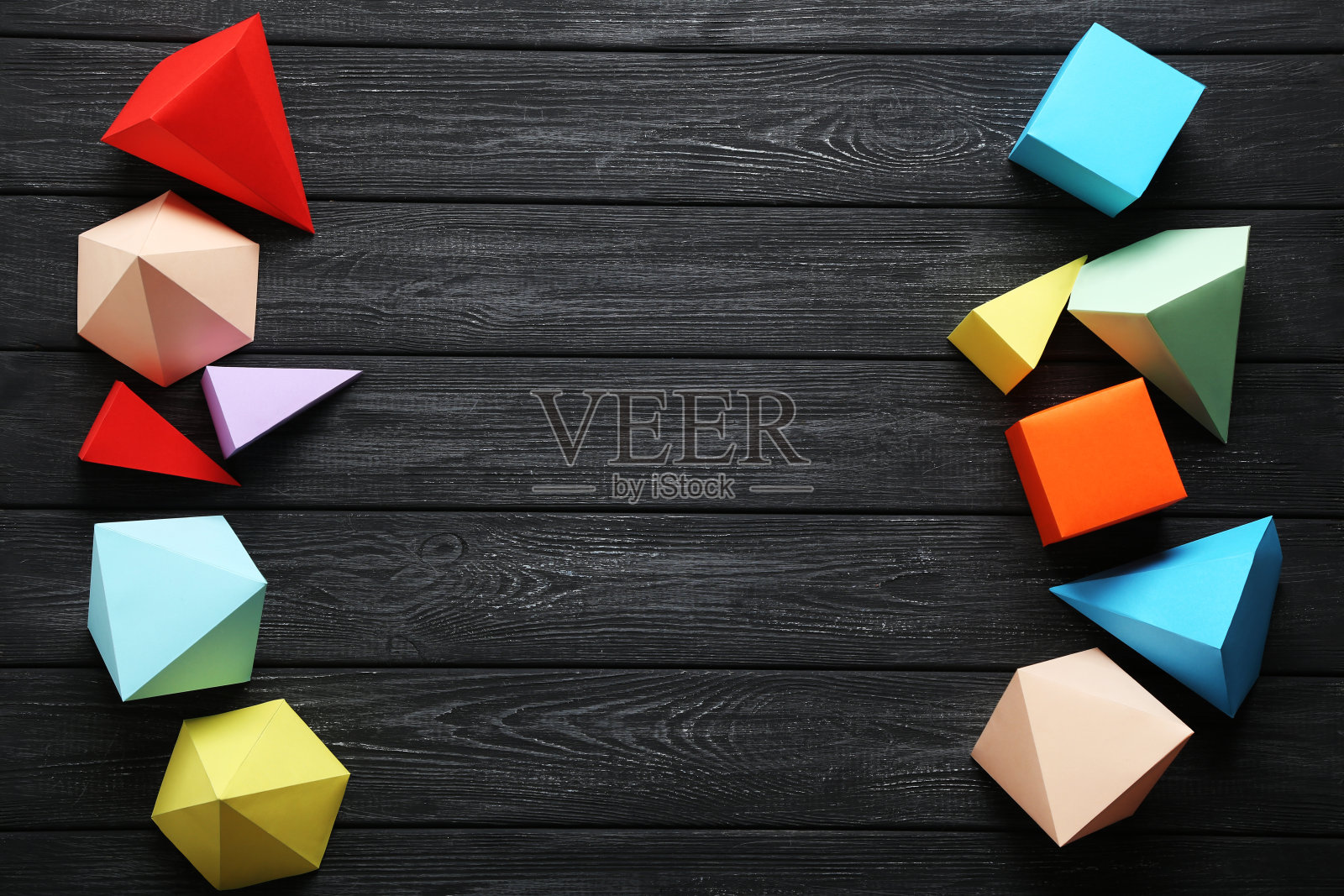 黑色木桌上的彩色纸几何图形照片摄影图片