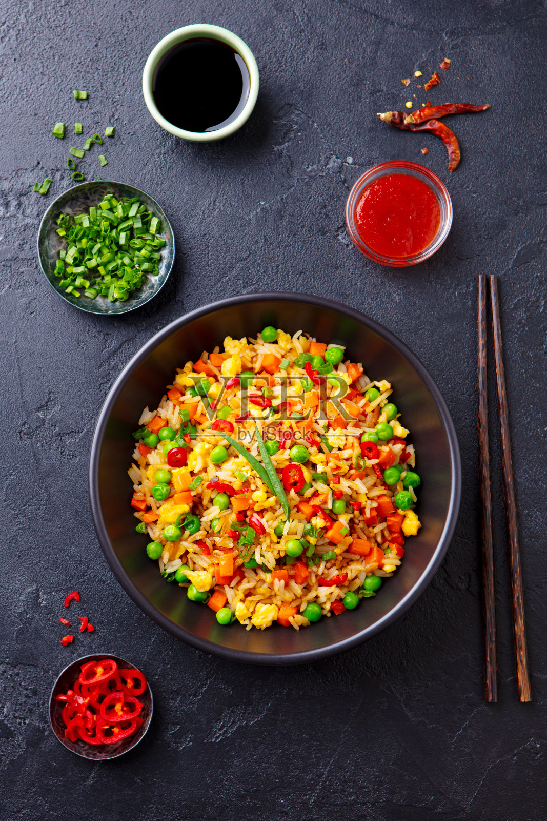 亚洲的鸡蛋和蔬菜炒饭。黑石的背景。前视图。照片摄影图片