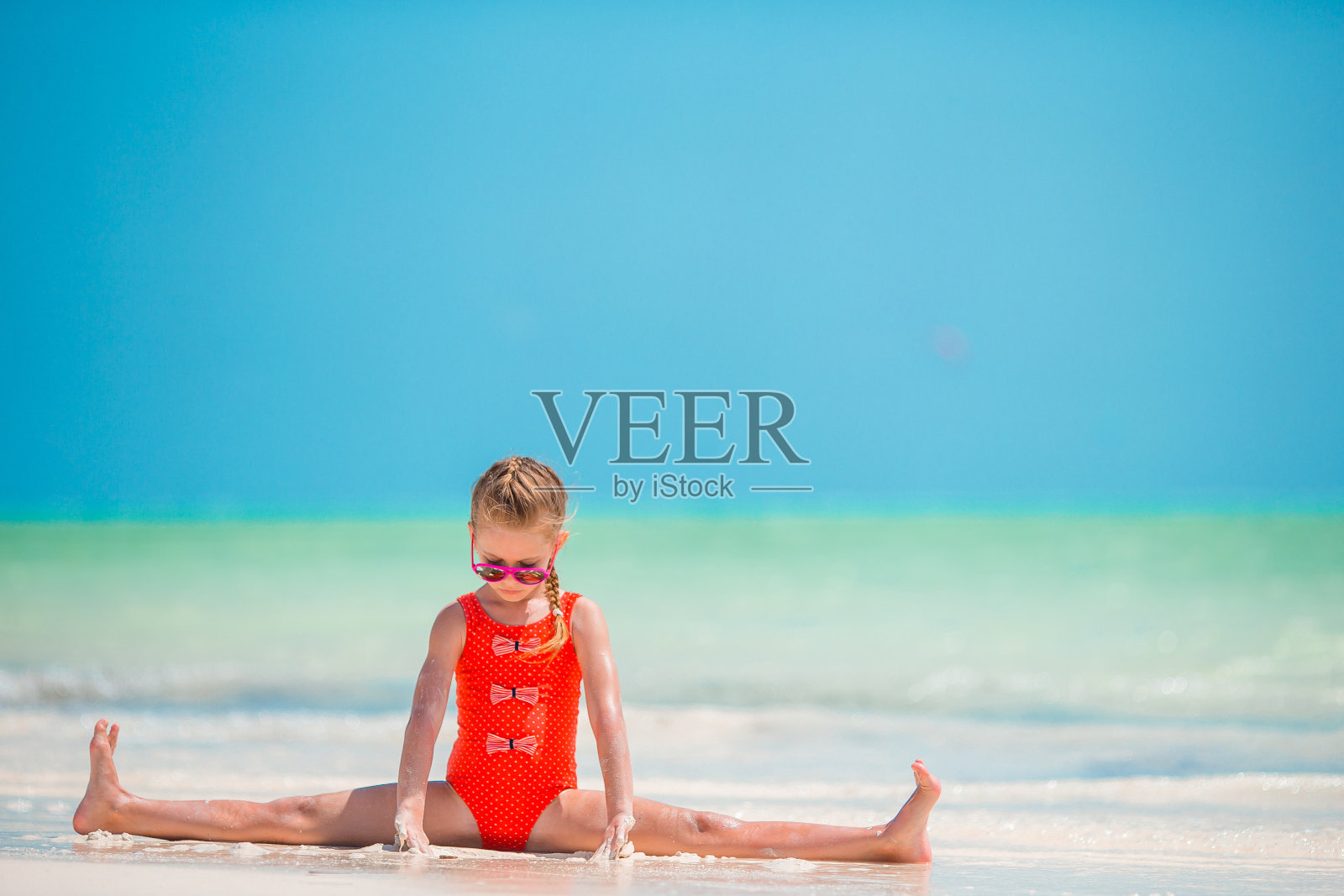 在白色沙滩上玩耍的活泼小女孩照片摄影图片