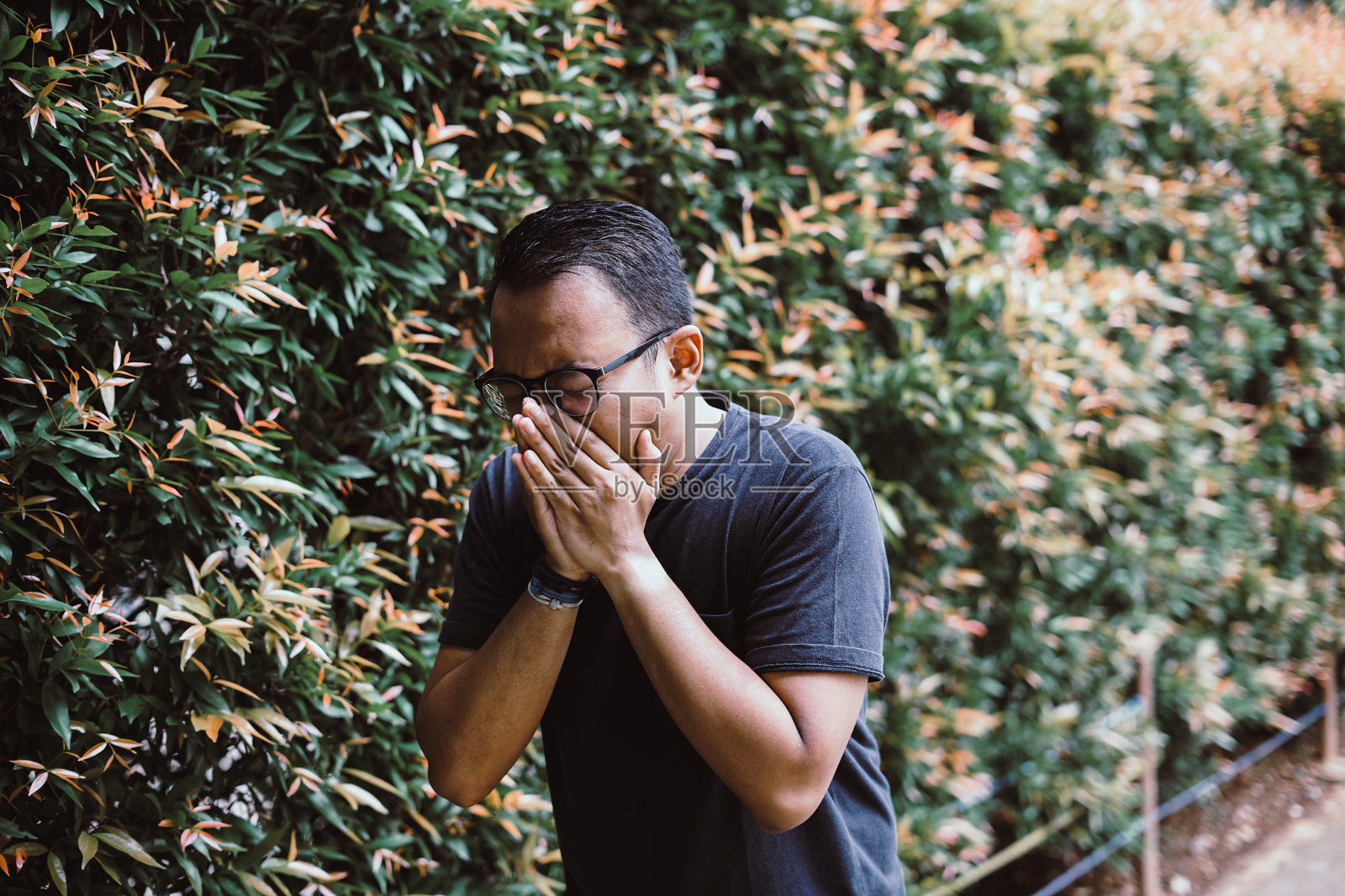 打喷嚏的年轻东南亚男子照片摄影图片