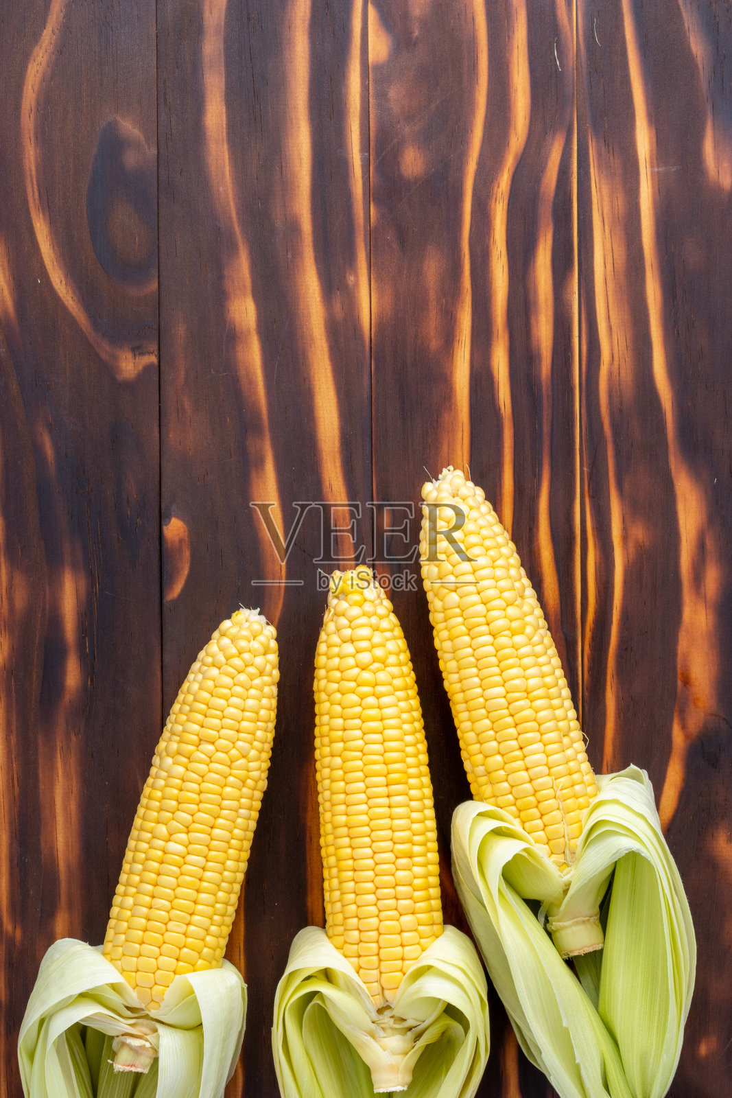 木桌上放着玉米棒照片摄影图片