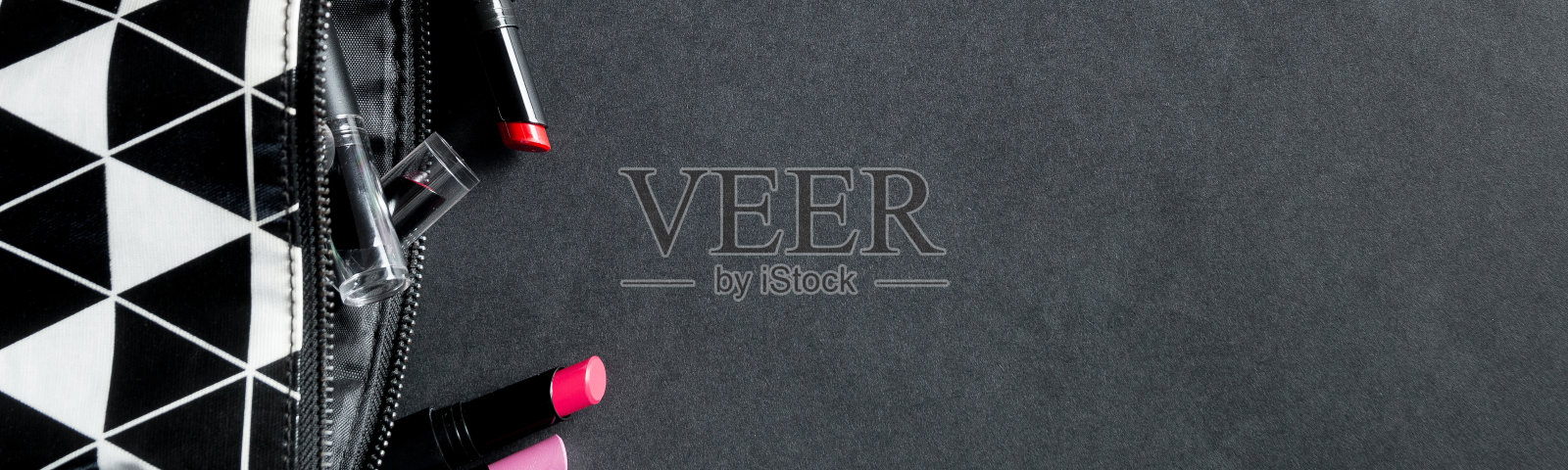 旗帜的黑色和白色化妆袋与一套口红。照片摄影图片