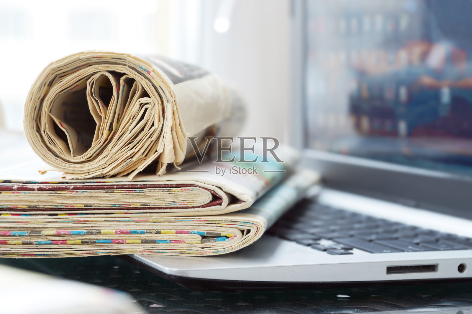 打开笔记本电脑，键盘上放着报纸照片摄影图片