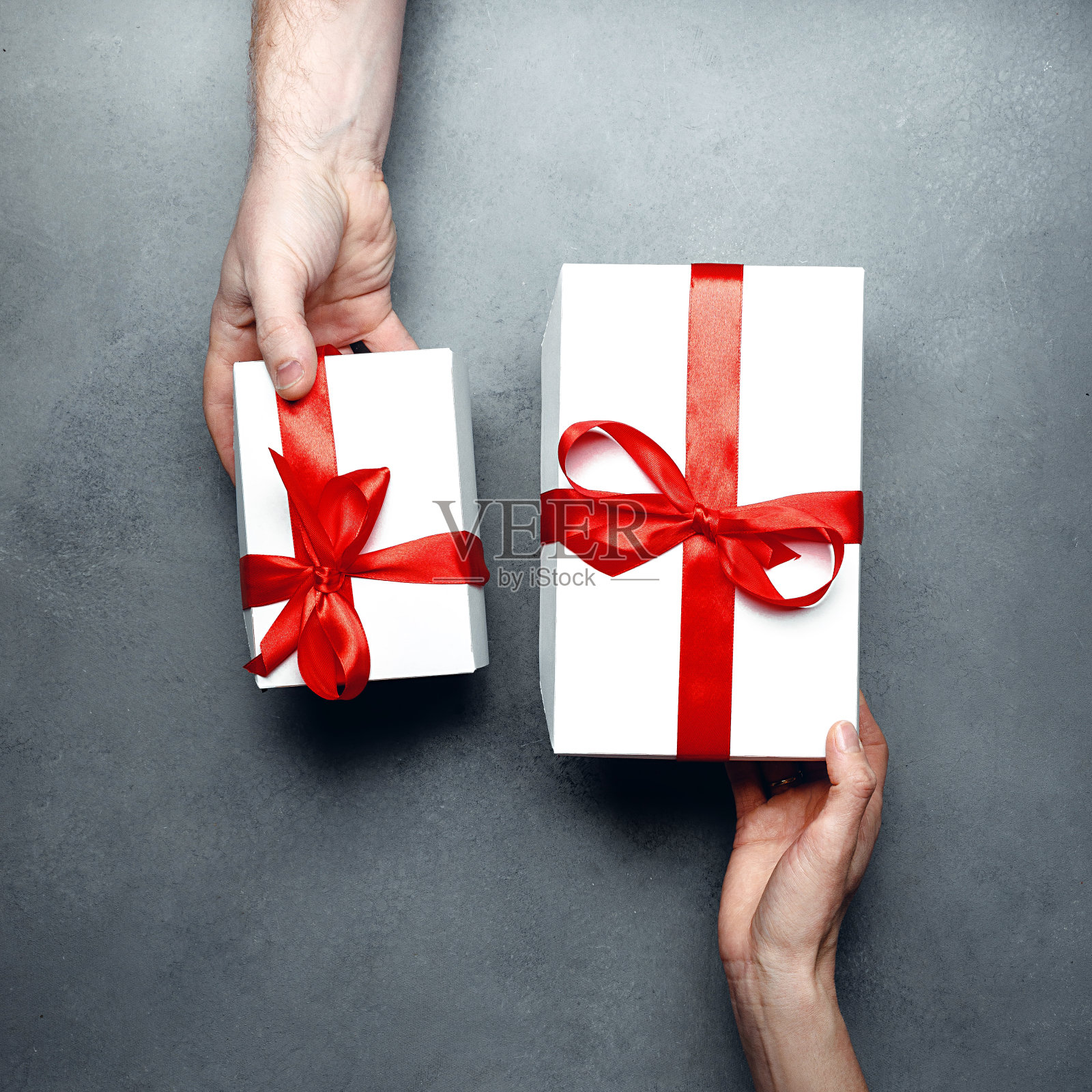 礼物交换的概念。男人和女人交换礼物，俯视图。生日，情人节，纪念日，节日概念照片摄影图片