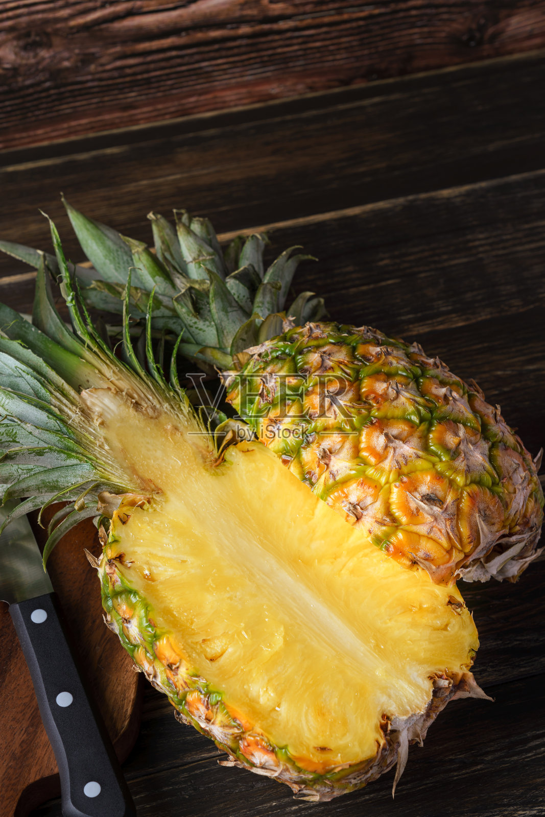新鲜菠萝和砧板放在木桌上照片摄影图片