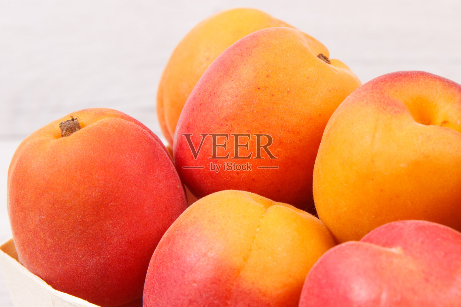 杏仁或桃子装在木盒里作为健康的零食或甜点。含有维生素和矿物质的食物照片摄影图片