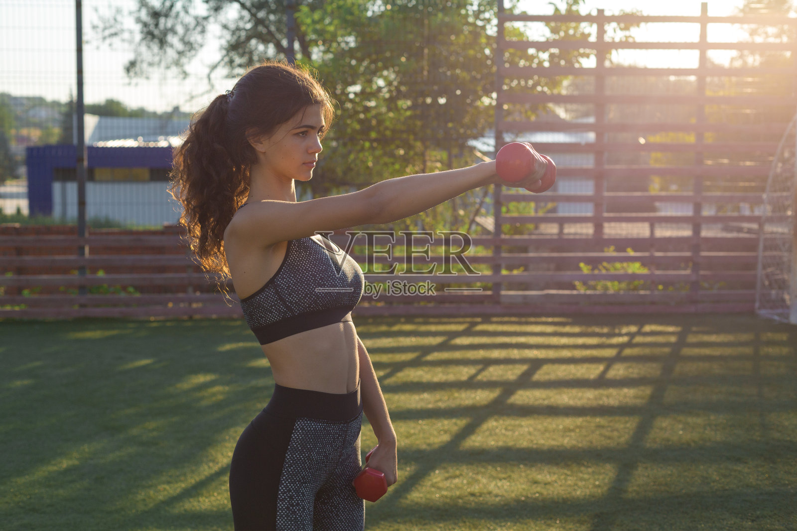 一个年轻苗条的运动女孩穿着印有蛇皮图案的运动服进行一套练习。健康的生活方式。照片摄影图片