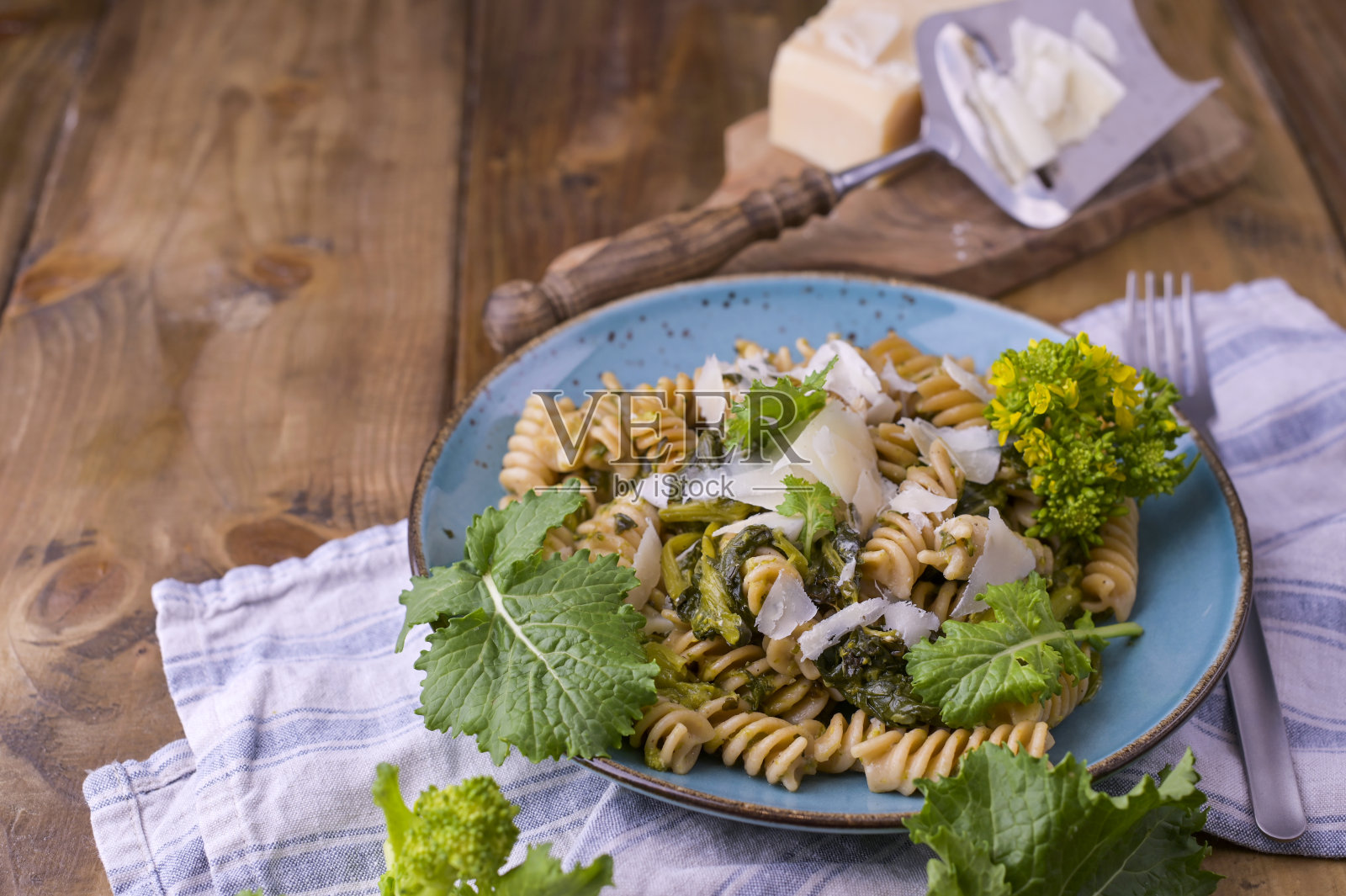 木桌上放着一盘意大利面和帕尔马干酪。意大利南部的传统食物，来自普利亚。乡村风格的照片。照片摄影图片