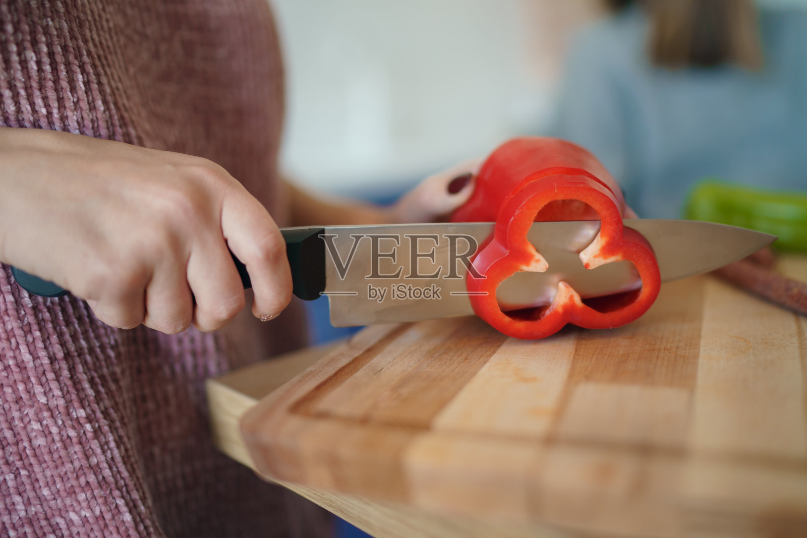 女人在木板上切甜椒的双手，切辣椒特写照片摄影图片
