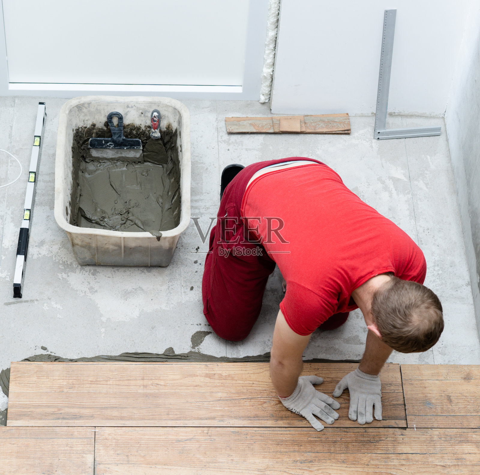 瓷砖工人在公寓地面铺设瓷砖照片摄影图片