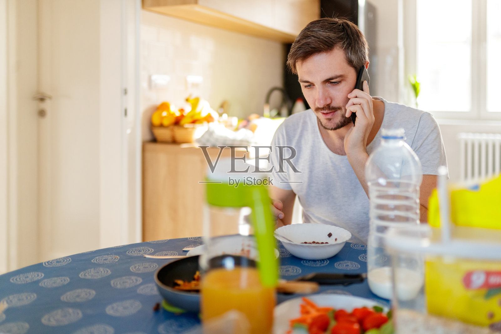 一个男人一边吃早餐一边用手机照片摄影图片