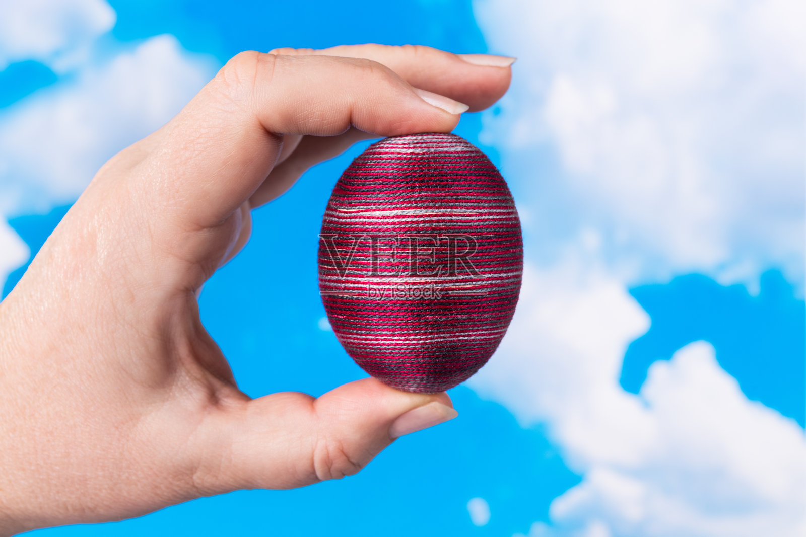 原来复活节彩蛋在女性手中，在春天蓝天的背景上照片摄影图片