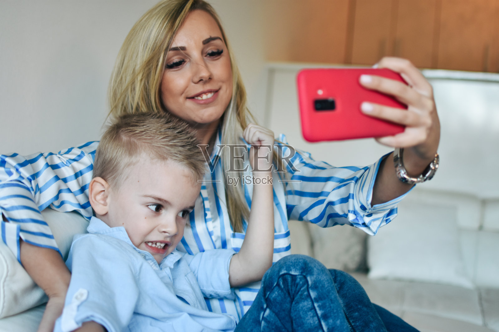 年轻的母亲用智能手机自拍照片摄影图片