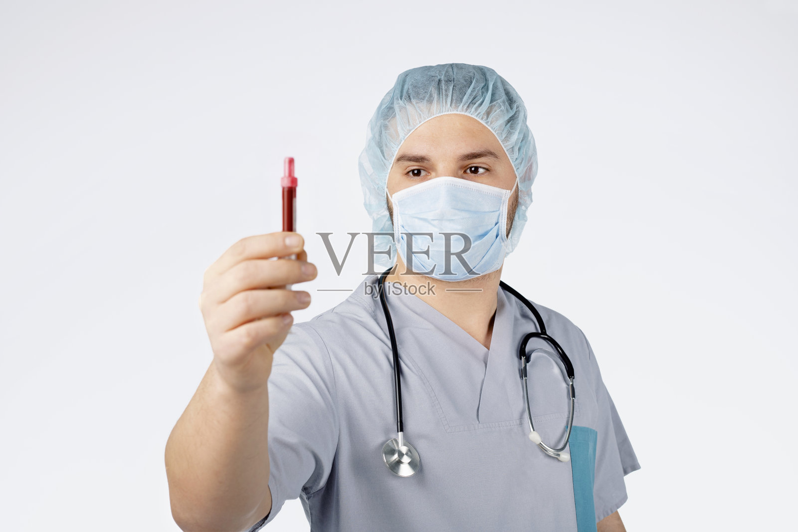 戴着听诊器的医生手持血液样本照片摄影图片