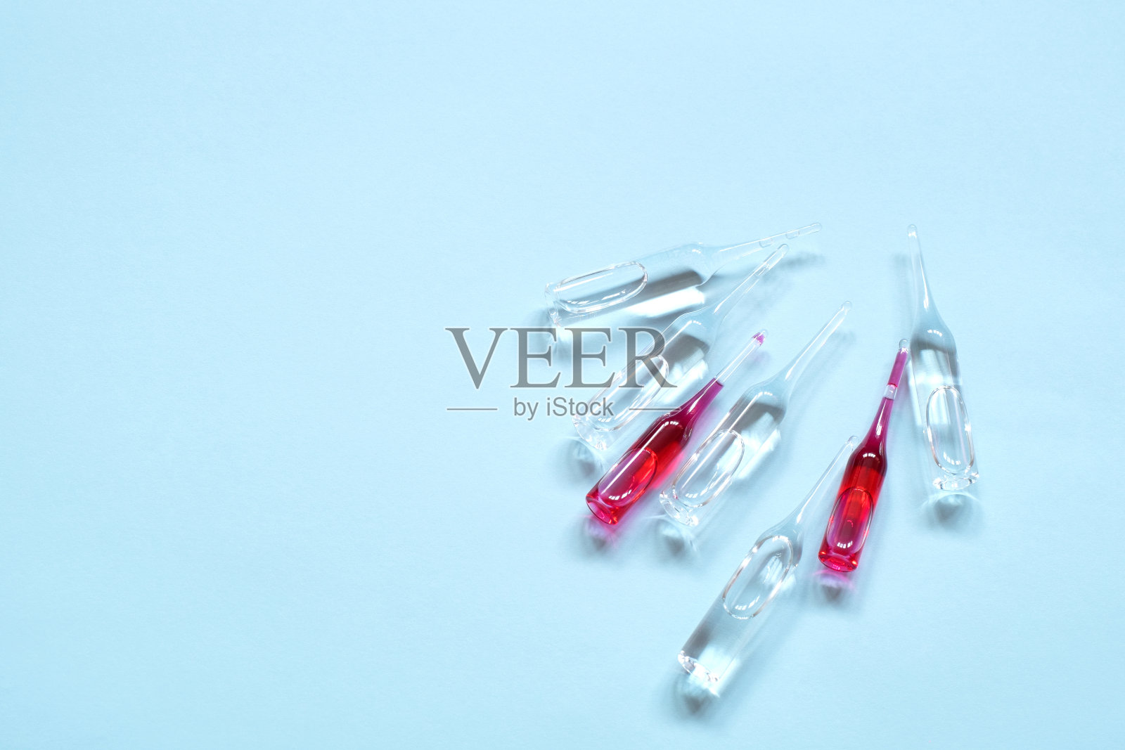 蓝色背景安瓿。照片摄影图片