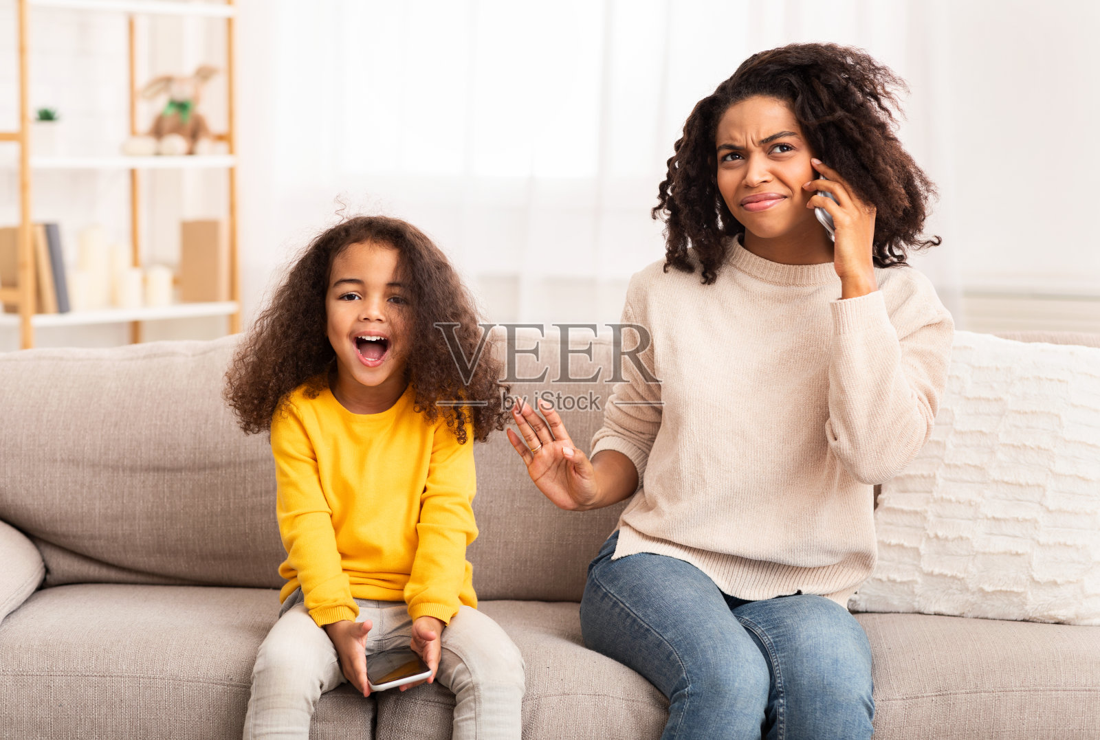 妈妈在家里打电话的时候，小女儿大喊大叫照片摄影图片