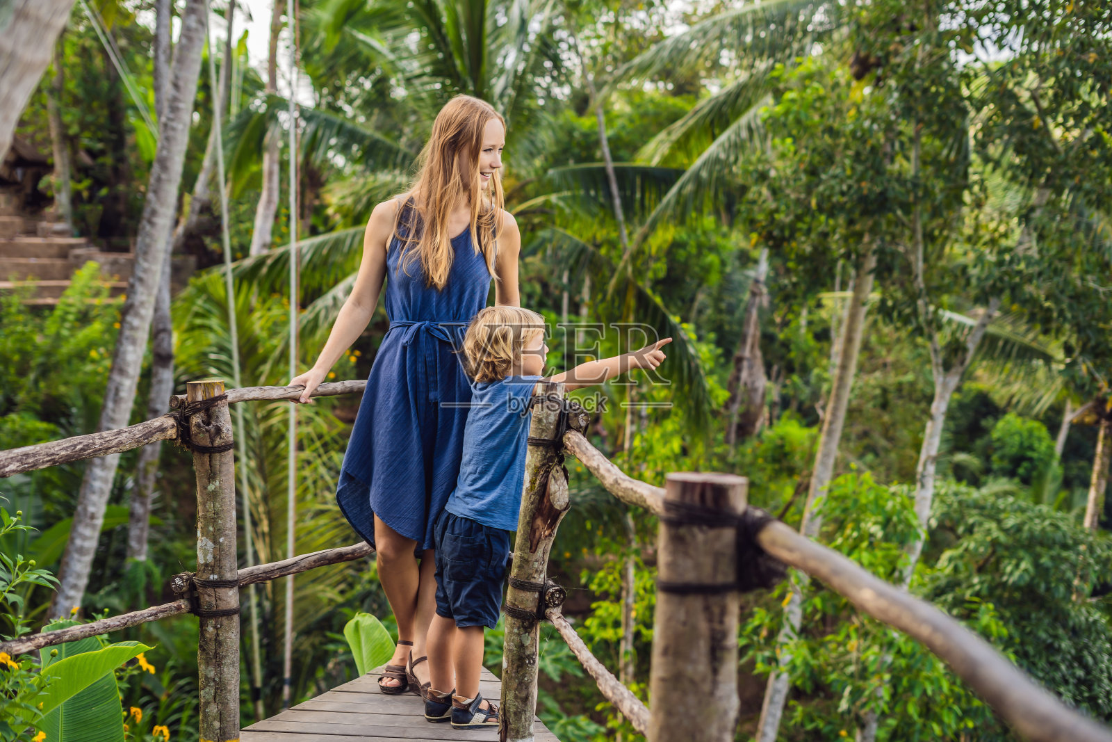 印度尼西亚巴厘岛：丛林背景下的观景台上，旅行中的母子照片摄影图片