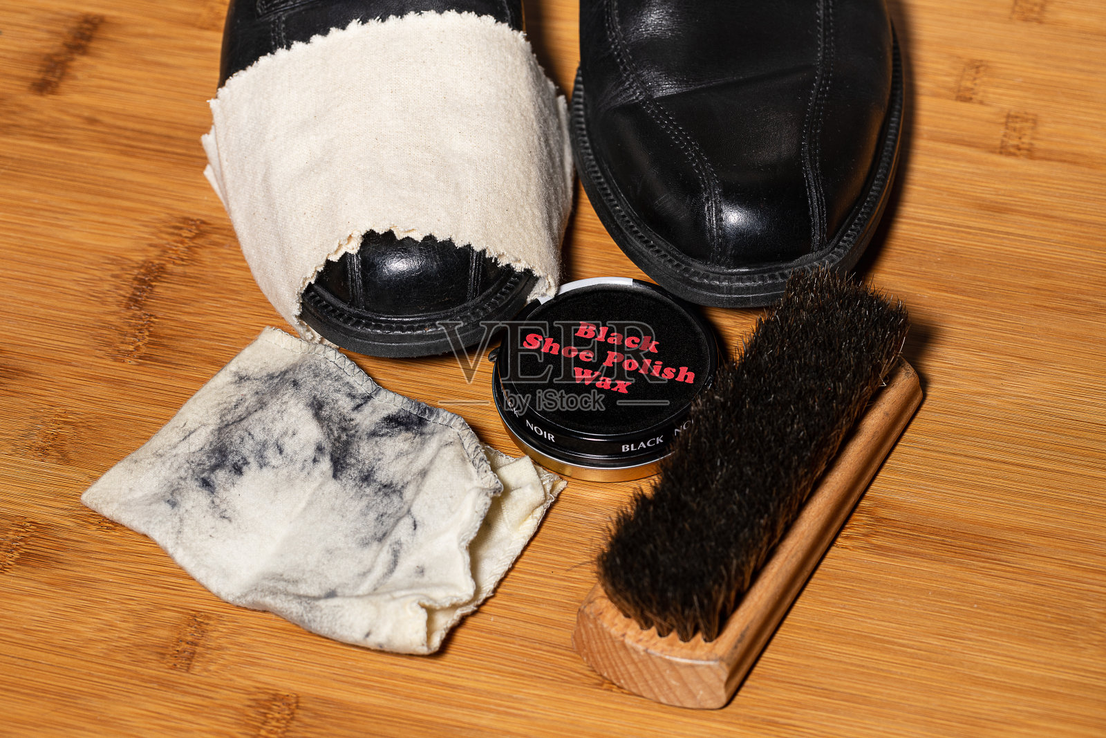 一双准备抛光的鞋子，周围是用于这个过程的配件在木地板上。在图像的各个地方都有复制的空间。照片摄影图片