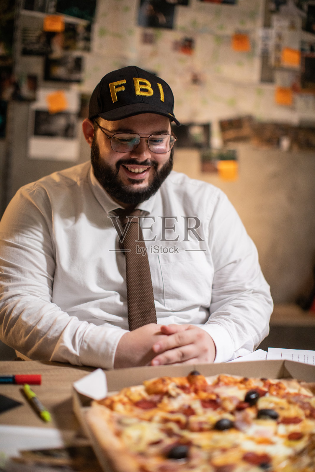 饥饿的联邦调查局探员在办公室看披萨照片摄影图片
