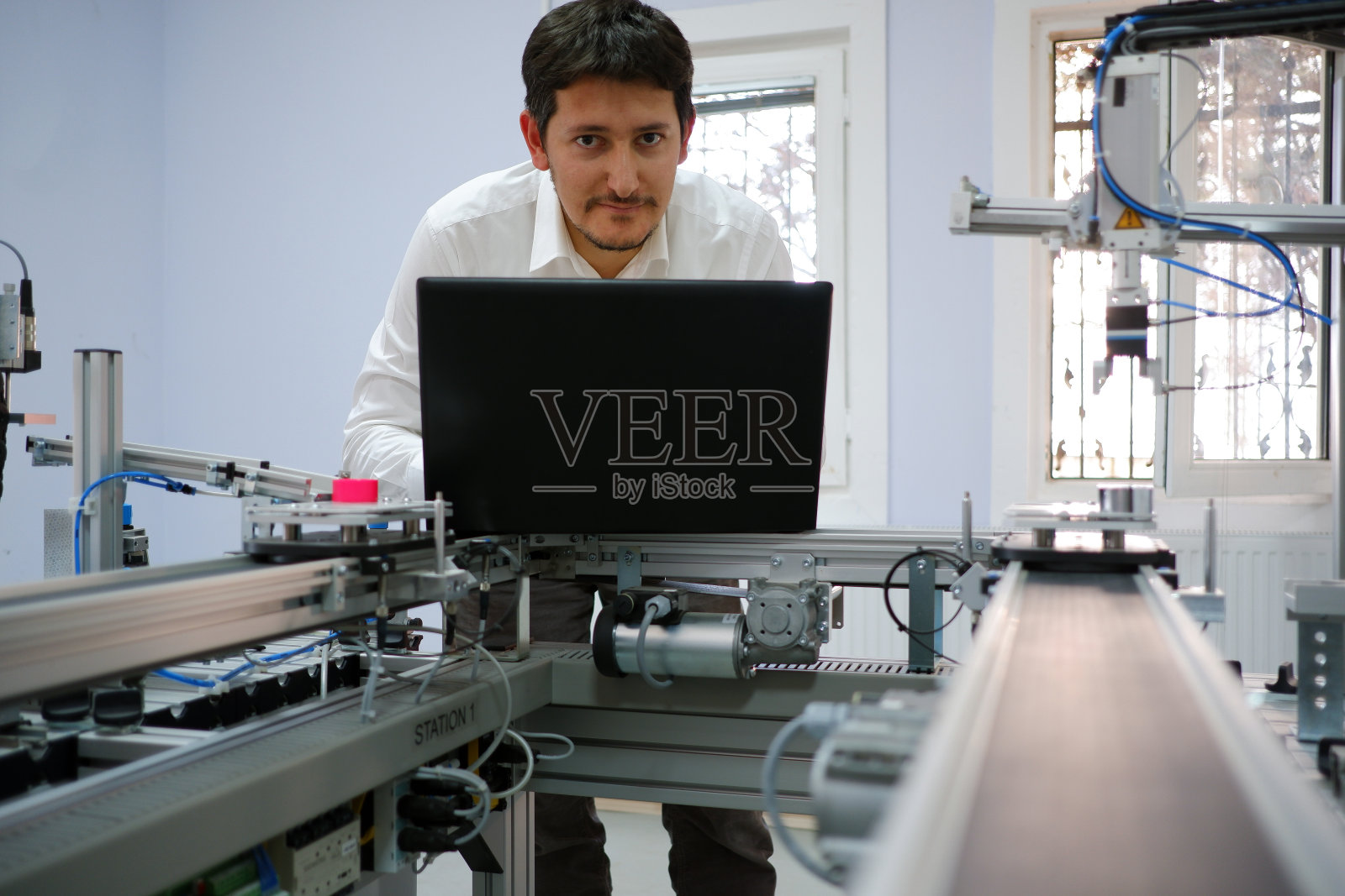 工程师在笔记本电脑上工作，对智能工厂的PLC进行编程照片摄影图片