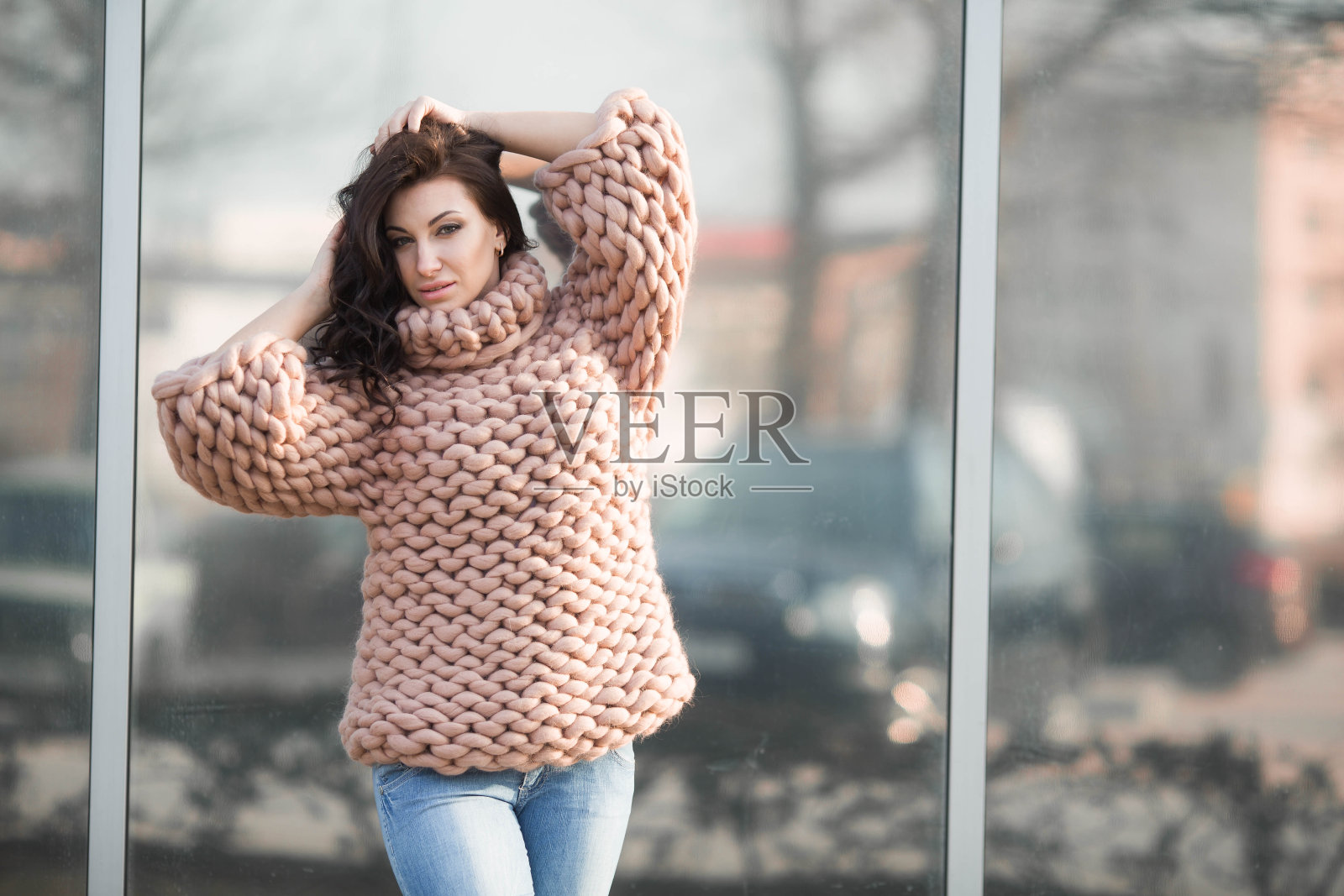 一个女孩穿着暖和的针织毛衣在街上照片摄影图片