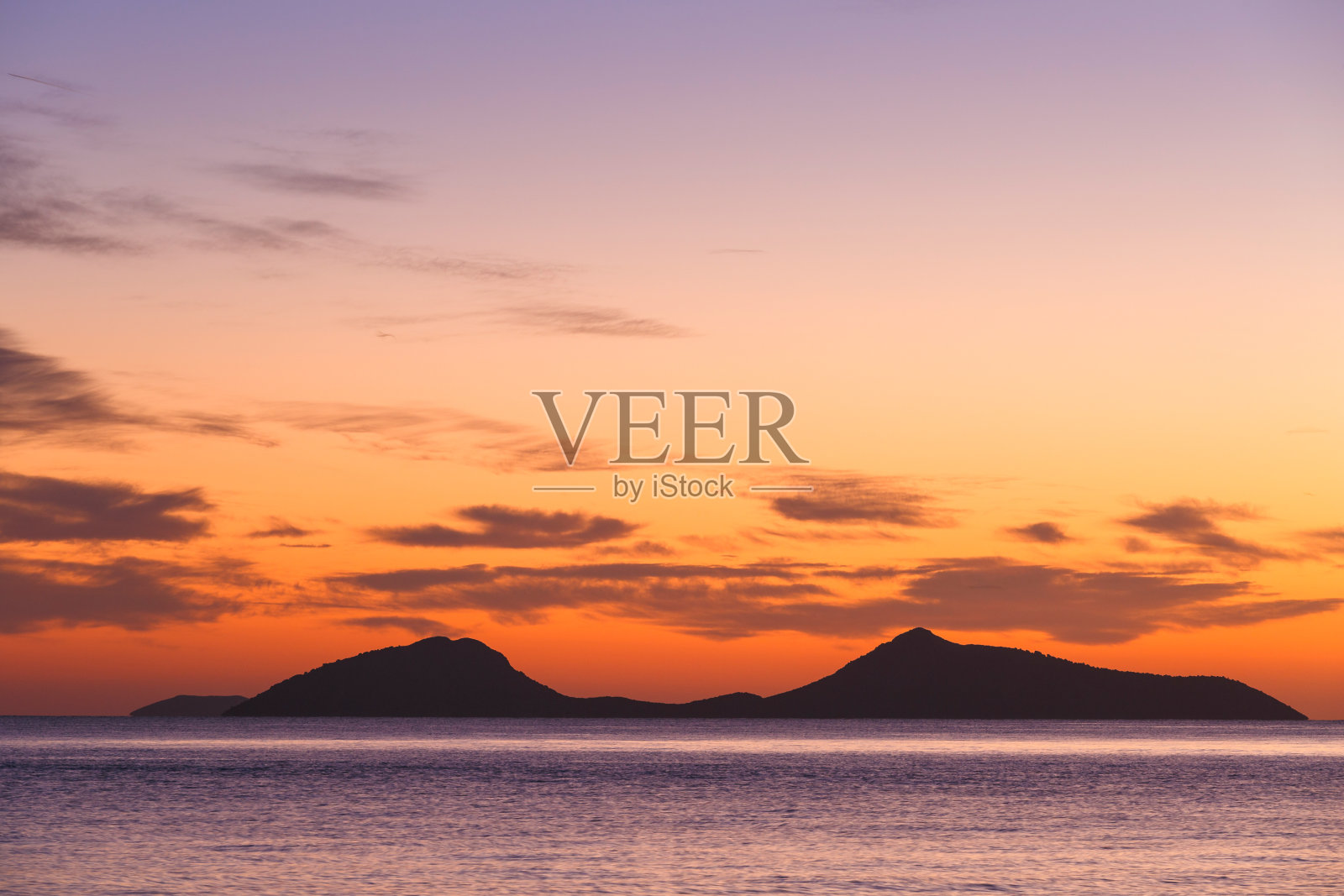 从Spetses看特里克里岛在多彩的早晨天空。照片摄影图片