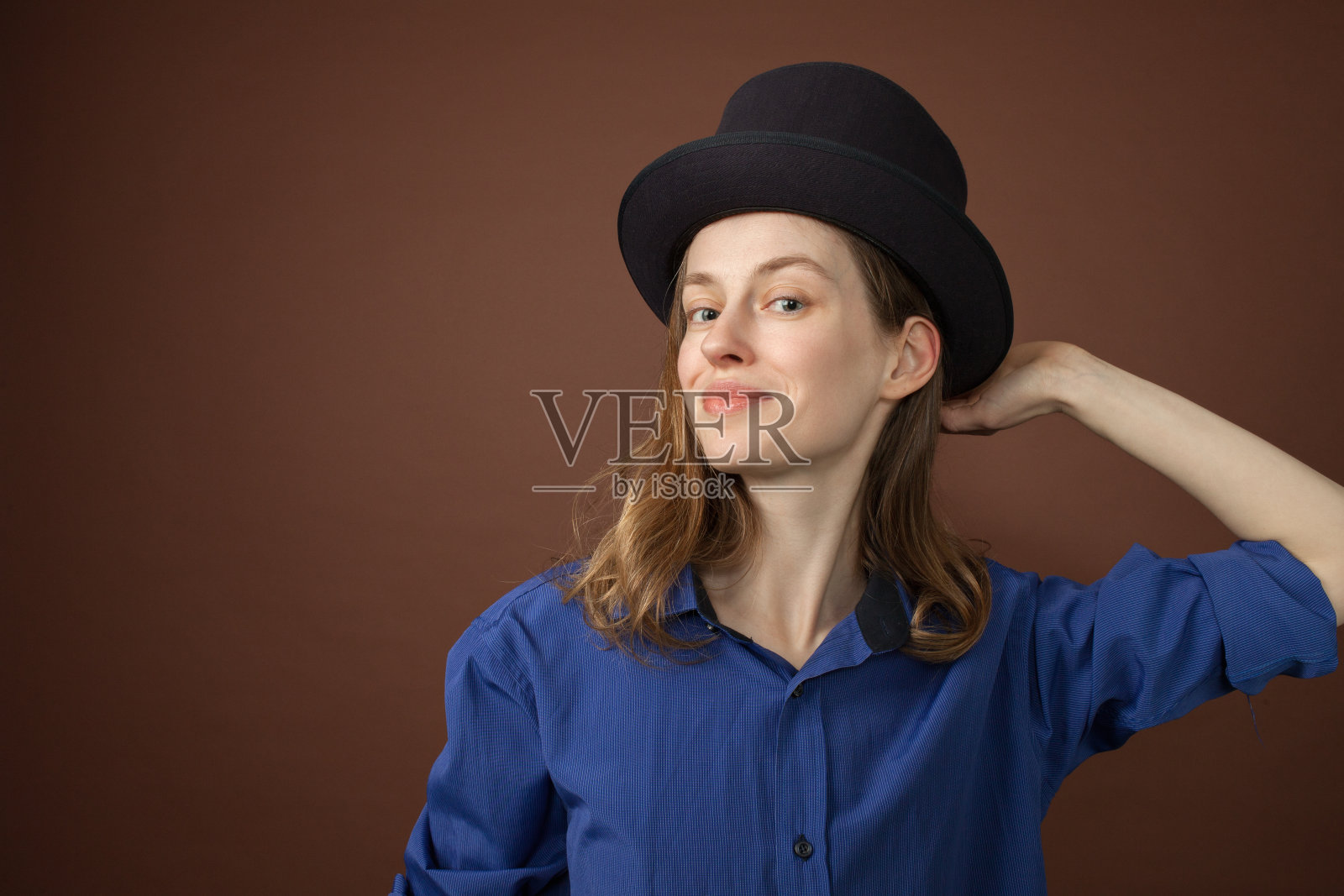 一个在棕色背景上的30岁女人的工作室肖像照片摄影图片