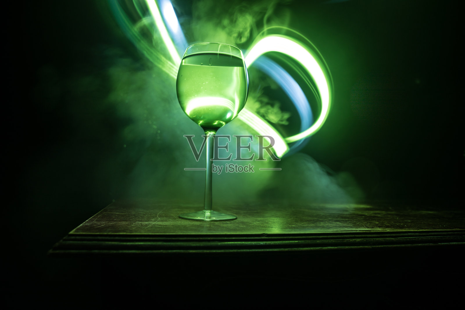 木墙背景上的木桌上放着一杯白葡萄酒照片摄影图片