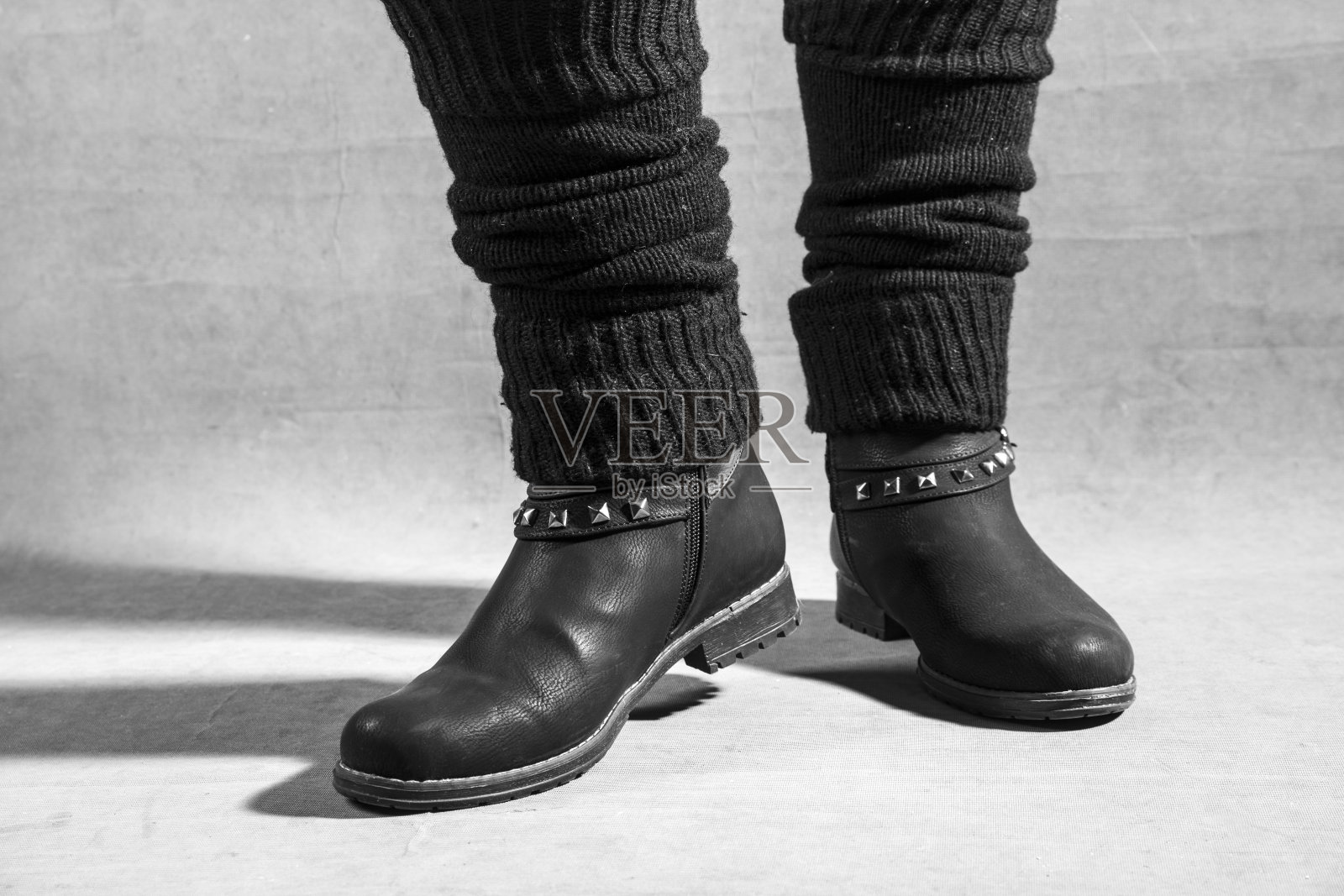 脚上穿着黑色女靴。摄影棚拍摄，黑白照片照片摄影图片