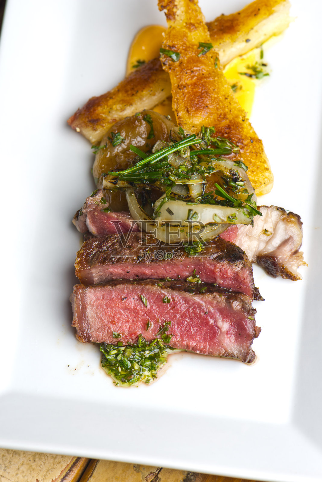 牛排配阿根廷香菜切碎，牛至，大蒜，橄榄油，醋，红辣椒片，安格斯草喂养牛肉和炸大蕉。照片摄影图片