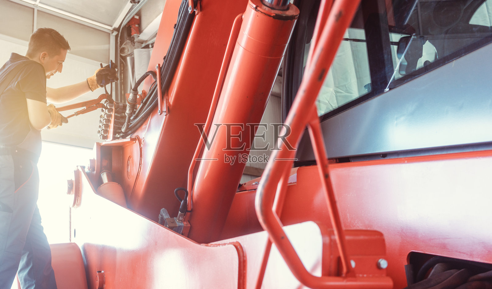 机械师在他的车库里修理一台巨大的农用机器照片摄影图片