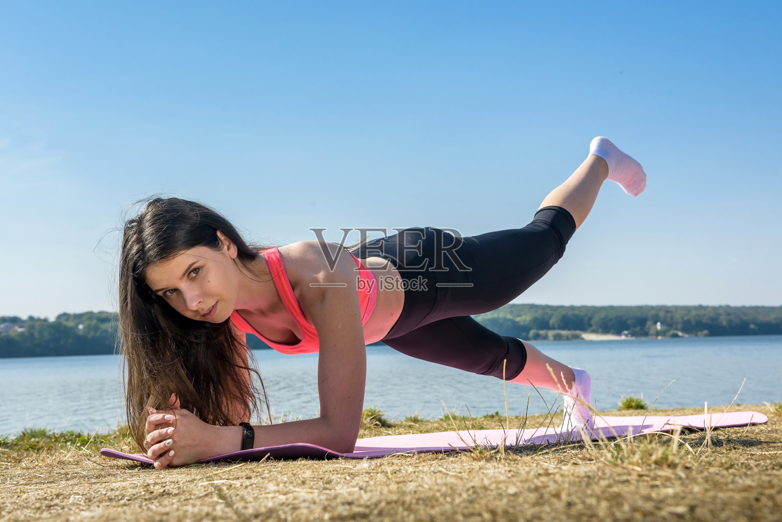 年轻女运动员湖边户外做俯卧撑照片摄影图片