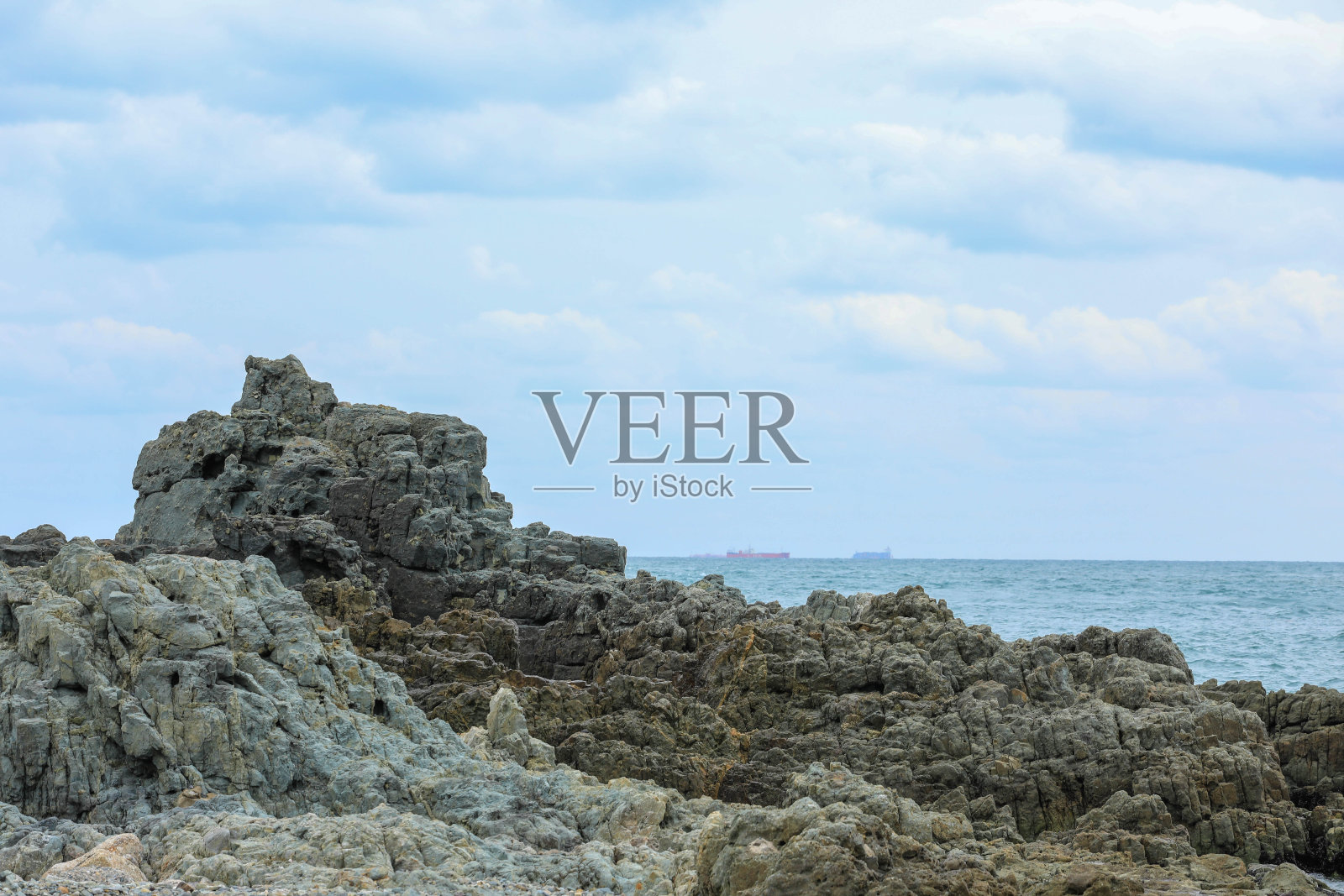 礁石浅滩石靠近大海，以蓝天为背景。韩国。照片摄影图片