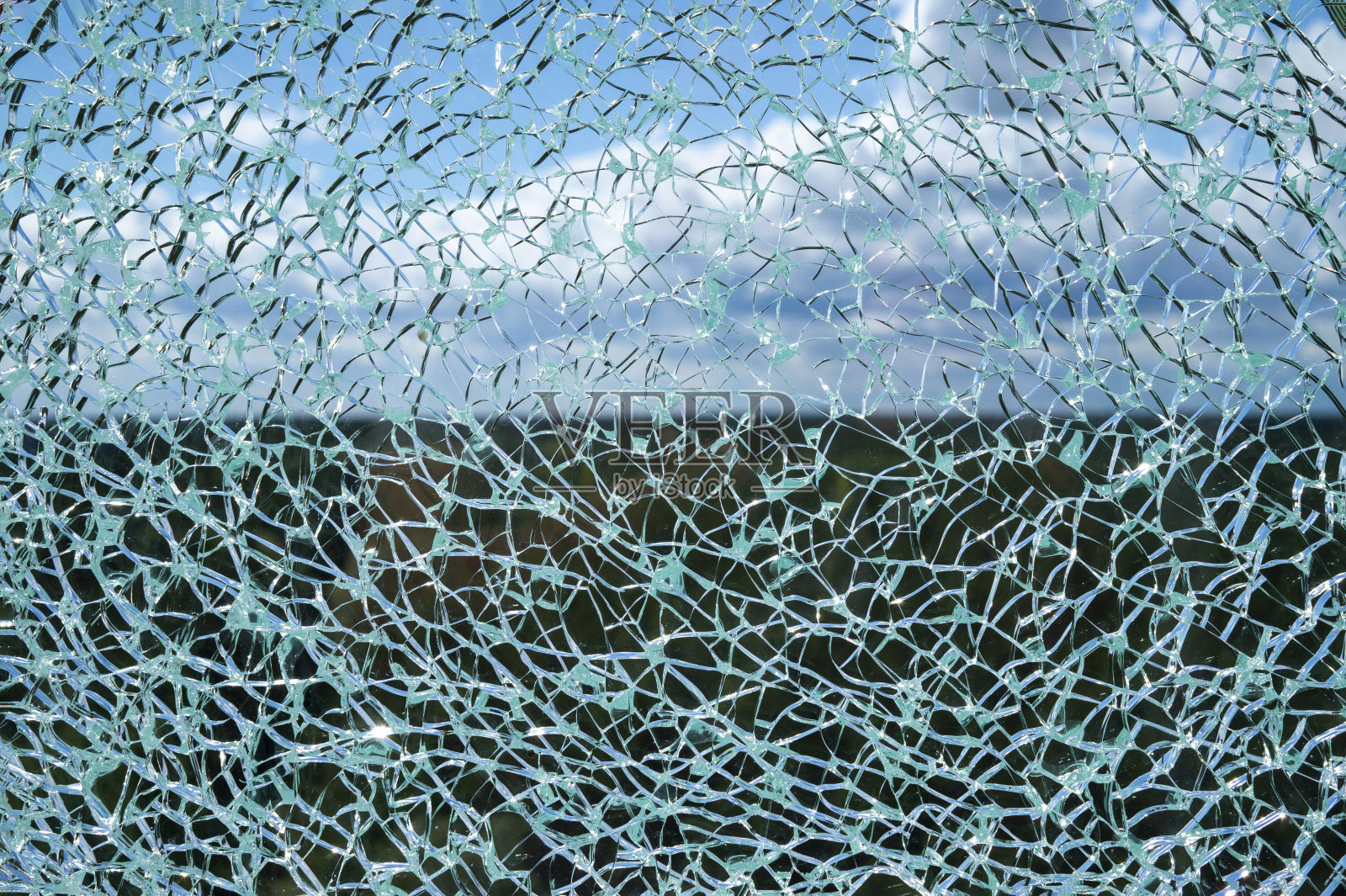 蓝天映衬下破碎的玻璃表面照片摄影图片