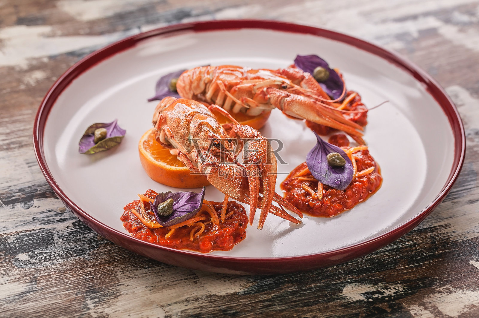 煮熟的龙虾。美味的辣椒酱，罗勒和酸豆盘。美食烹饪照片摄影图片