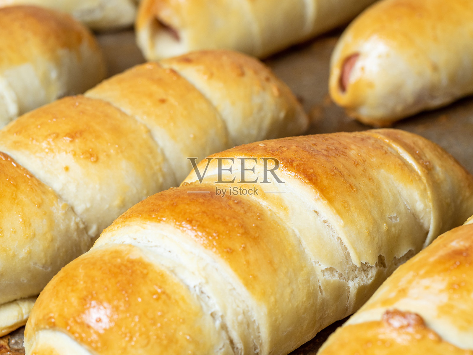 面团里有现成多汁的香肠。一个面粉产品的特写照片摄影图片