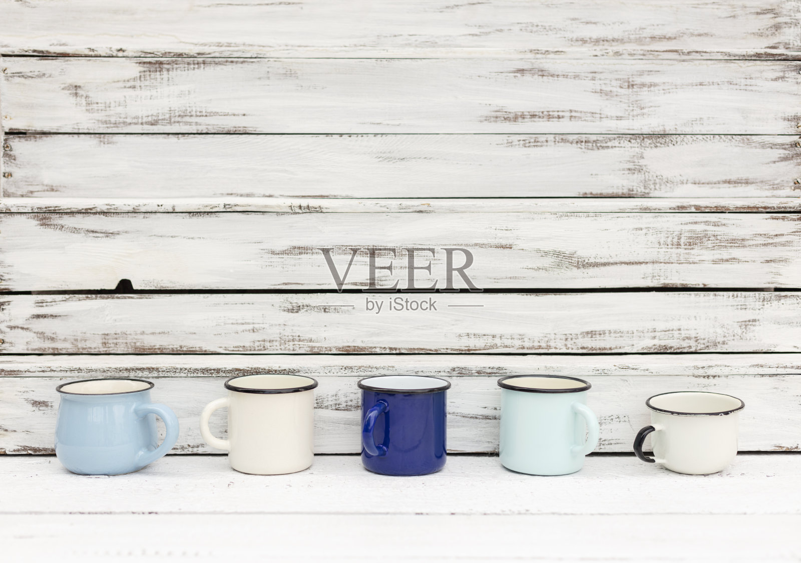 复古风格的搪瓷马克杯在一个古老的木制背景。照片摄影图片