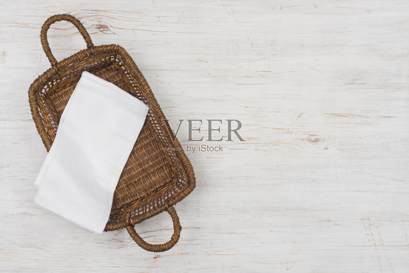 柳条篮子顶视图与白布上的木制背景照片摄影图片