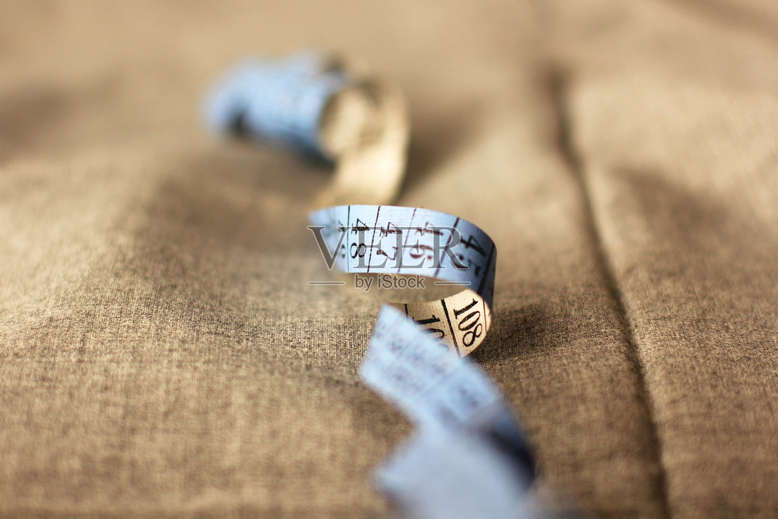 缝纫用卷尺特写：布料上的卷尺照片摄影图片