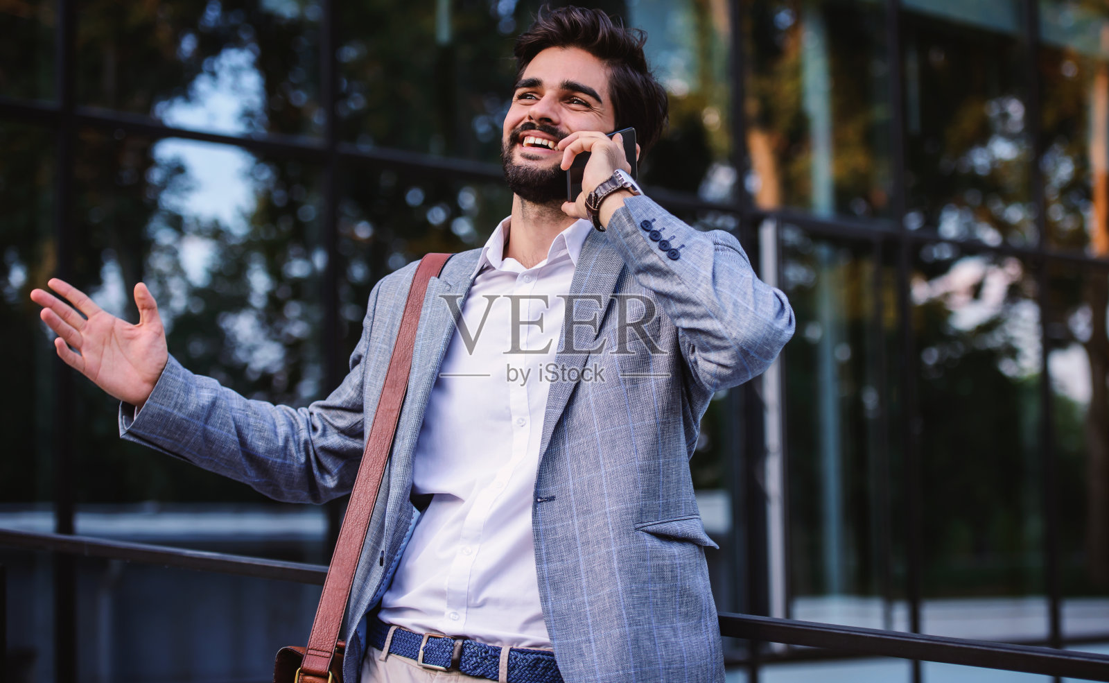 商人在公司前面用手机交谈。商业、教育、生活理念照片摄影图片