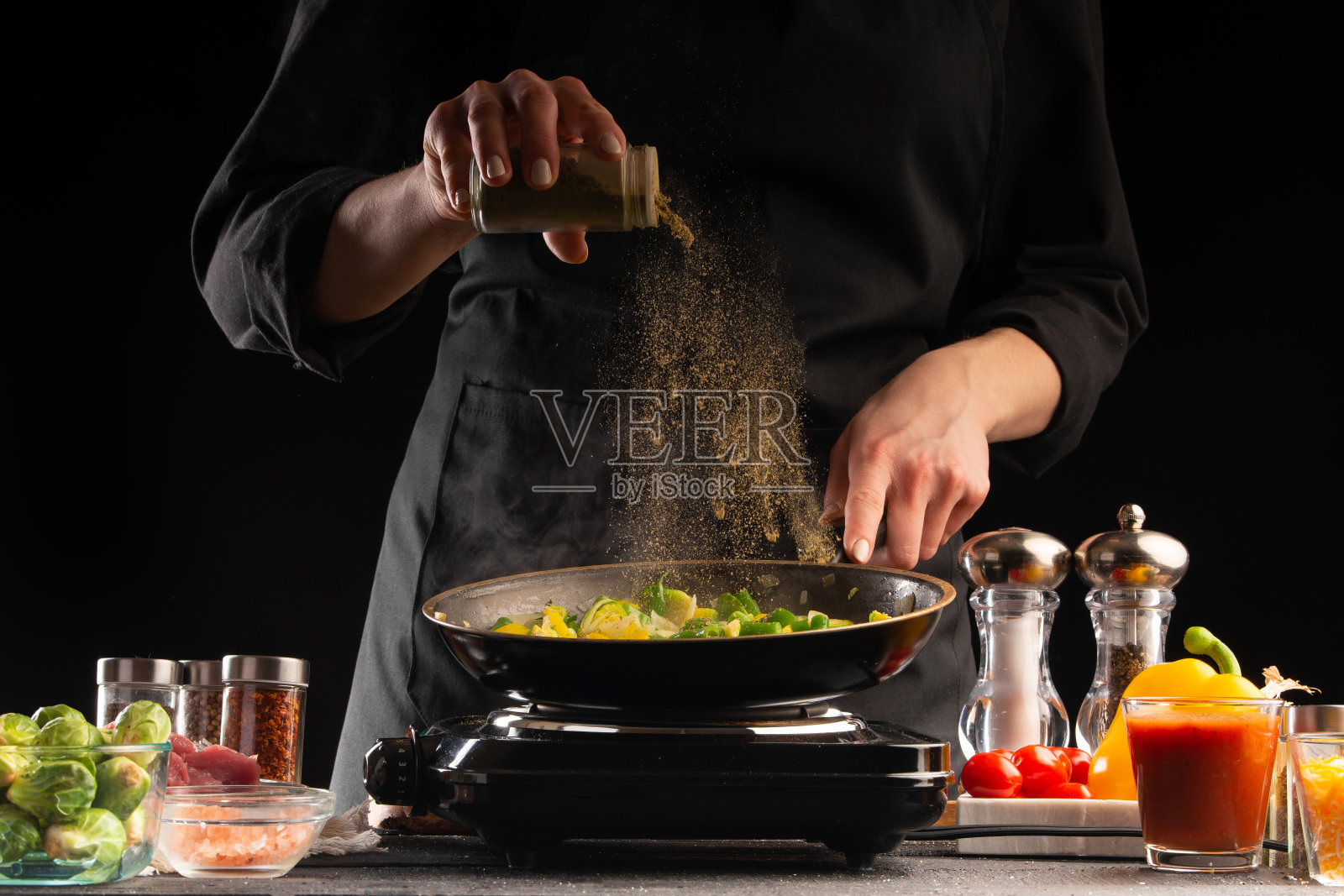 厨师在平底锅里煎肉，撒上调味料，动作定格，美味健康的食物，蔬菜和肉类，餐厅和酒店业务，食谱照片摄影图片