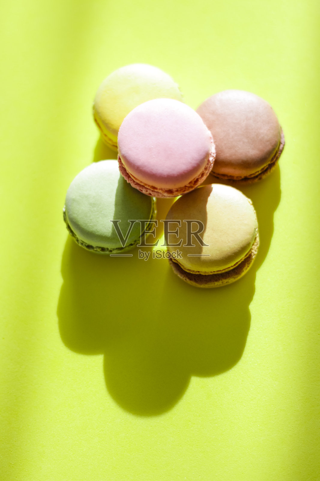 色彩丰富的杏仁饼干在柠檬绿色的背景下，选择性的聚焦照片摄影图片