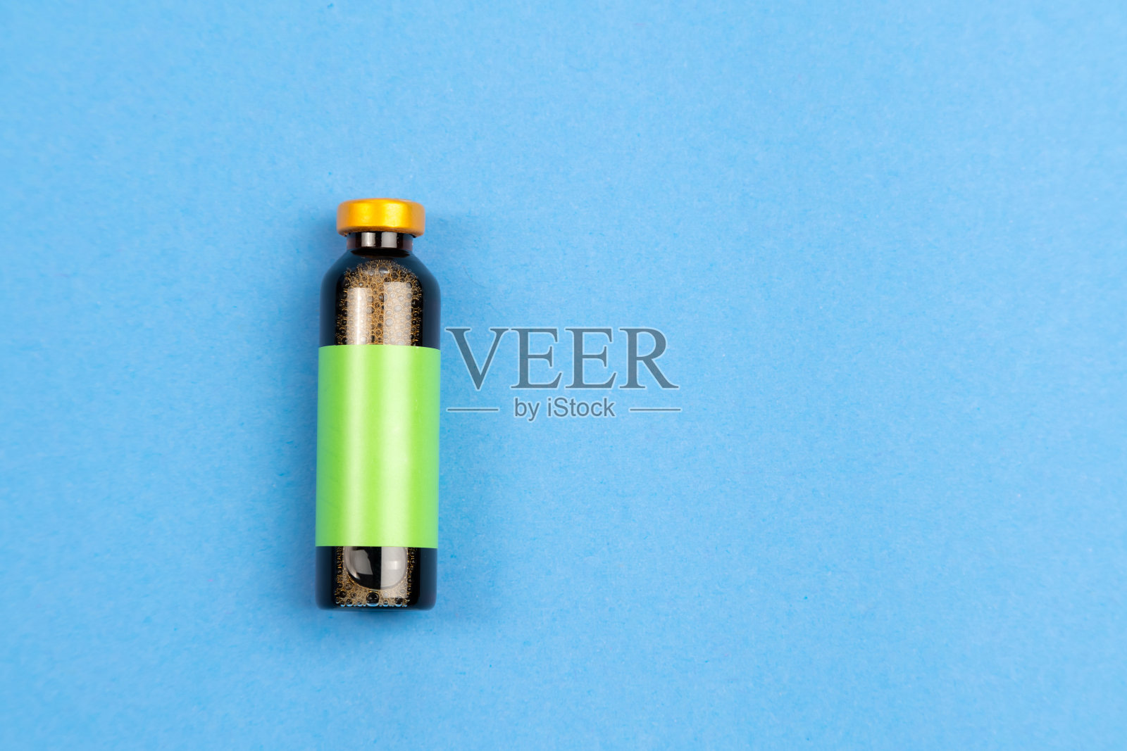 蓝色背景上有流感疫苗的瓶子。医学创新。医学特写照片摄影图片