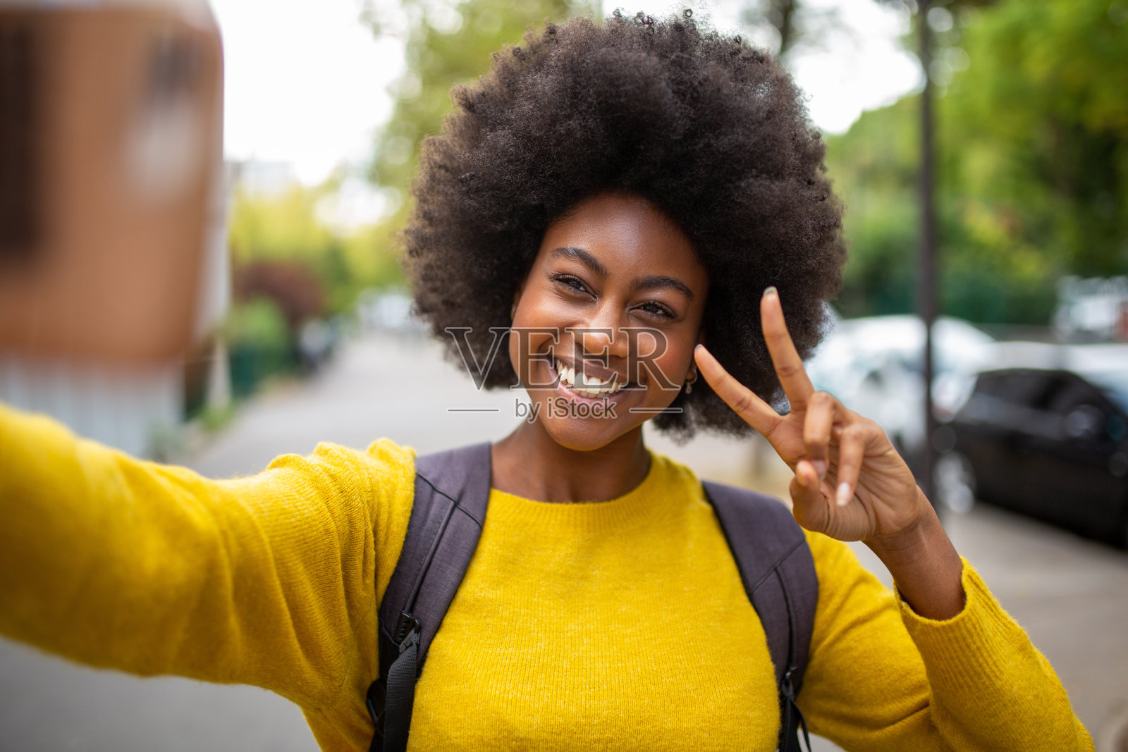 微笑的非洲女人在户外用手机自拍照片摄影图片