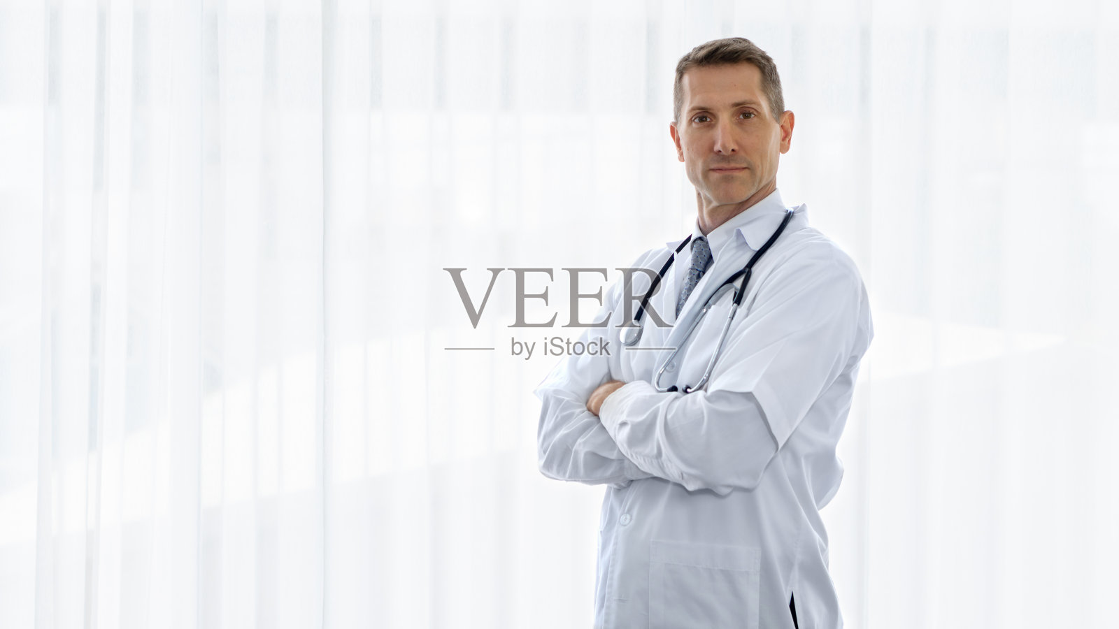 穿白色实验服、戴听诊器的白人理疗医生人像照片摄影图片